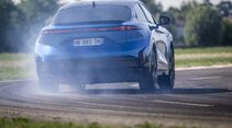 Heckansicht des Alpine A390 GTS auf einer Teststrecke mit Rauchentwicklung an den Reifen.