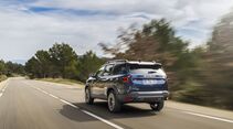 Heckansicht des Dacia Bigster während der Fahrt auf einer Landstraße