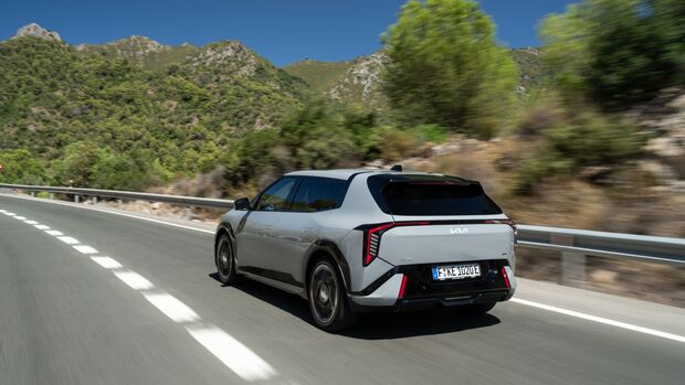 Heckansicht des Kia EV4 GT-Line während der Fahrt mit durchgehendem LED-Leuchtenband.