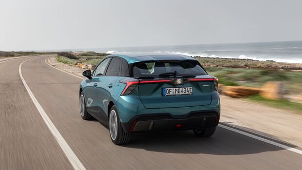 Heckansicht des MG4 EV Modellpflege während der Fahrt auf einer Küstenstraße.