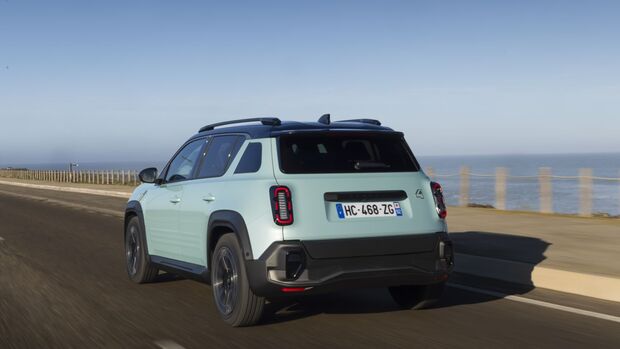 Heckansicht des Renault 4 E-Tech auf einer Küstenstraße bei Tageslicht