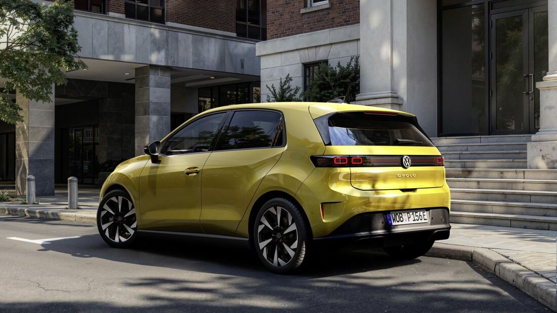 Heckansicht des VW ID.Polo in Gelb, geparkt vor einem modernen Gebäude in einer städtischen Umgebung.