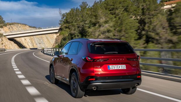 Heckansicht des roten Mazda CX-5 waehrend der Fahrt auf einer Landstrasse