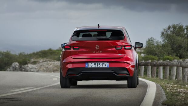 Heckansicht eines roten Renault Clio auf einer Straße, Rückleuchten und Renault-Logo sichtbar.