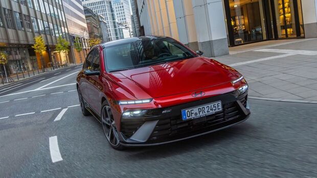 Hyundai IONIQ 6 Facelift in roter Lackierung während der Fahrt im urbanen Umfeld.