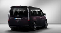 Hyundai Staria Elektro in dunkler Lackierung aus schräger Heckansicht mit vertikalen Rückleuchten.