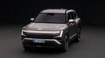 Hyundai Tucson SUV in Grau, aufgenommen schräg von vorne im Studio, mit beleuchtetem LED-Lichtband und vertikalen Tagfahrleuchten.