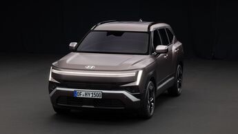 Hyundai Tucson SUV in Grau, aufgenommen schräg von vorne im Studio, mit beleuchtetem LED-Lichtband und vertikalen Tagfahrleuchten.