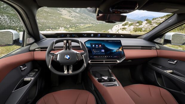 Innenraum des BMW 3er mit Lenkrad, digitaler Instrumentenanzeige, zentralem Display und rotbrauner Innenausstattung.
