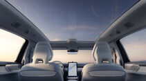 Innenraum des Volvo ES90 mit Panoramaglasdach und zentralem Touchscreen aus Rücksitzperspektive