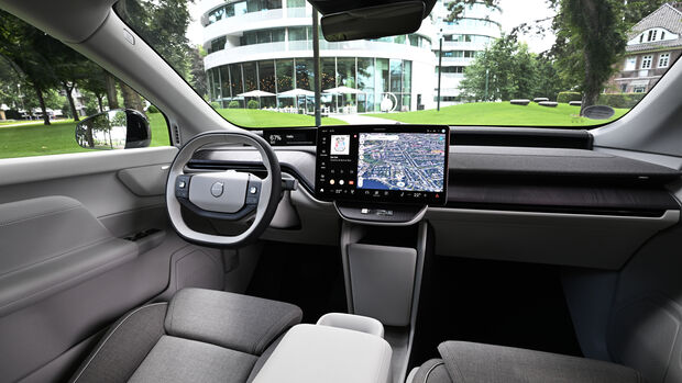 Innenraum des Volvo EX60 mit zentralem Touchscreen, digitalem Fahrerdisplay und hellem Cockpit.