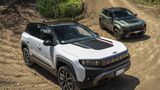 Jeep Compass 4xe vorne und Jeep Avenger 4xe hinten auf einer unbefestigten Strecke im Gelände.