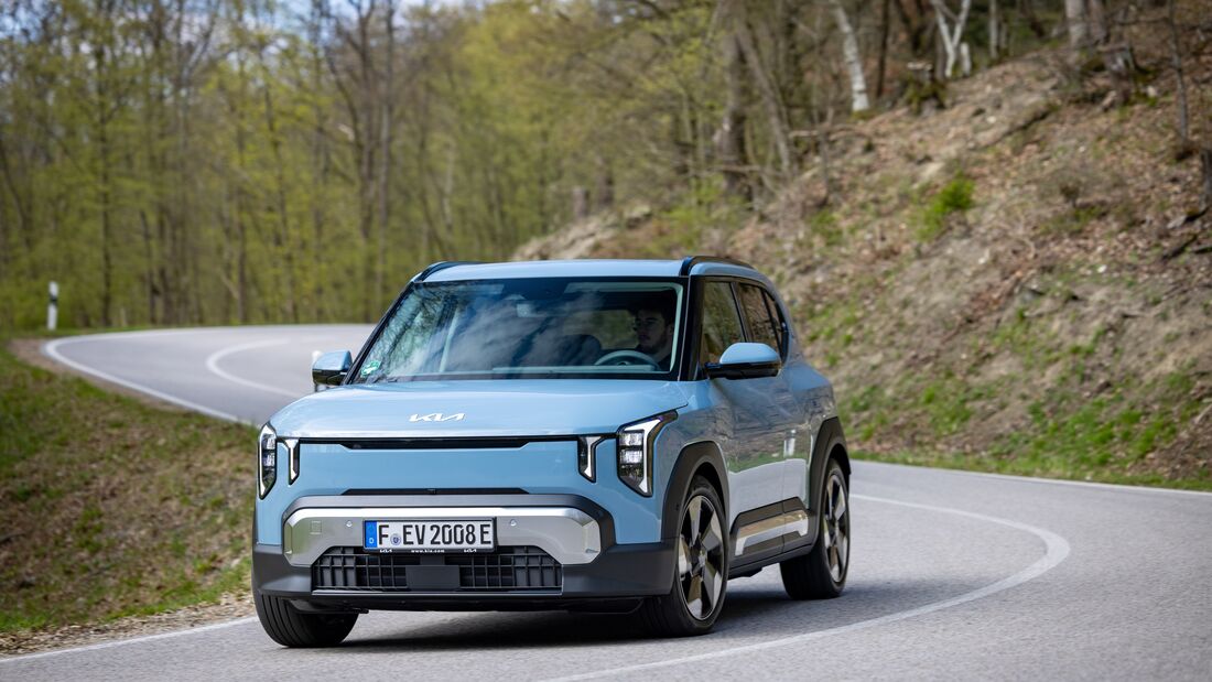 Kia EV2 in Frontansicht bei Fahrt durch eine Kurve auf Landstraße
