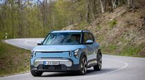 Kia EV2 in Frontansicht bei Fahrt durch eine Kurve auf Landstraße