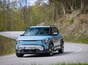 Kia EV2 in Frontansicht bei Fahrt durch eine Kurve auf Landstraße
