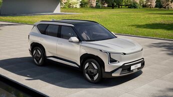 Kia EV5 Elektro-SUV in heller Lackierung als Front-Seitenansicht auf befestigter Fläche im Außenbereich