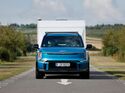 Kia EV9 Elektroauto zieht einen Wohnwagen auf einer Landstraße