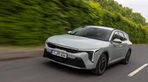 Kia K4 Sportswagon in Bewegung auf einer Straße mit seitlicher Frontperspektive.