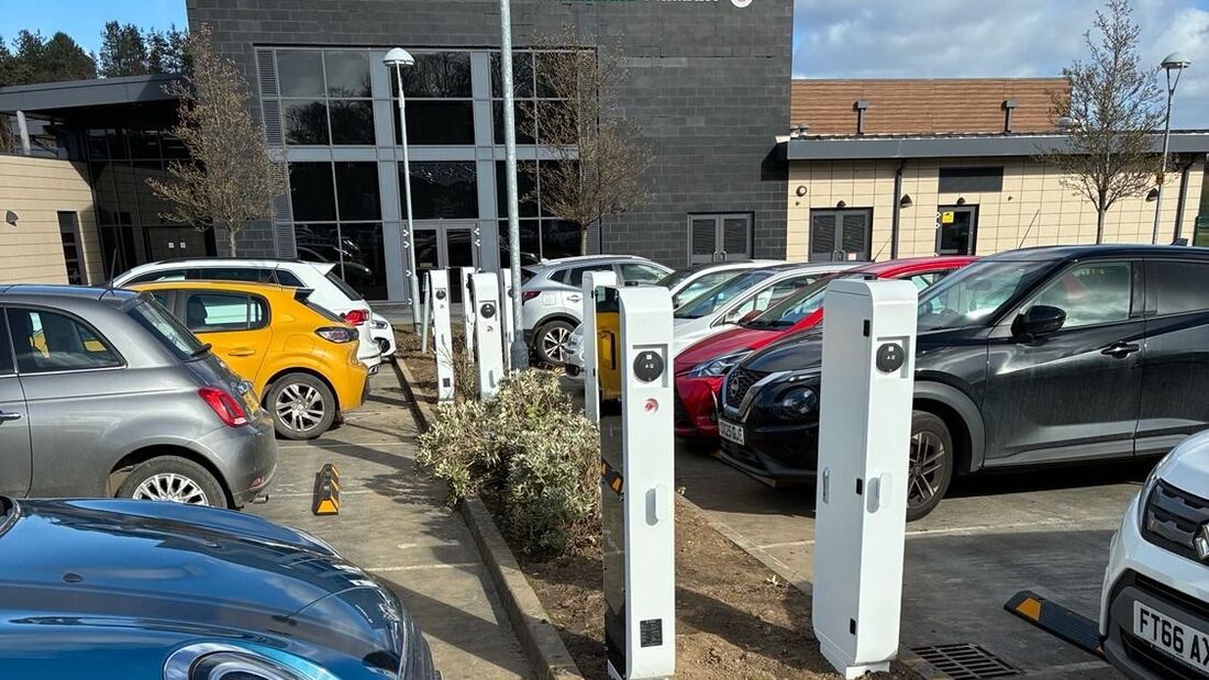 Ladepunkte von Tellus Power auf einem Parkplatz mit mehreren abgestellten Fahrzeugen