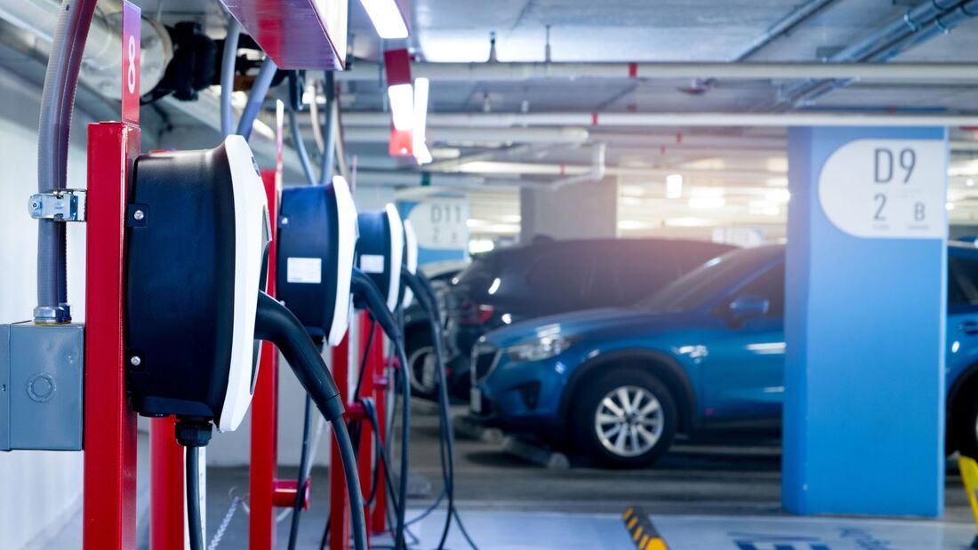 Ladestationen in einer Tiefgarage mit mehreren geparkten Fahrzeugen, die an Wallboxen für das Depotladen angeschlossen sind.