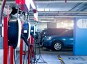 Ladestationen in einer Tiefgarage mit mehreren geparkten Fahrzeugen, die an Wallboxen für das Depotladen angeschlossen sind.