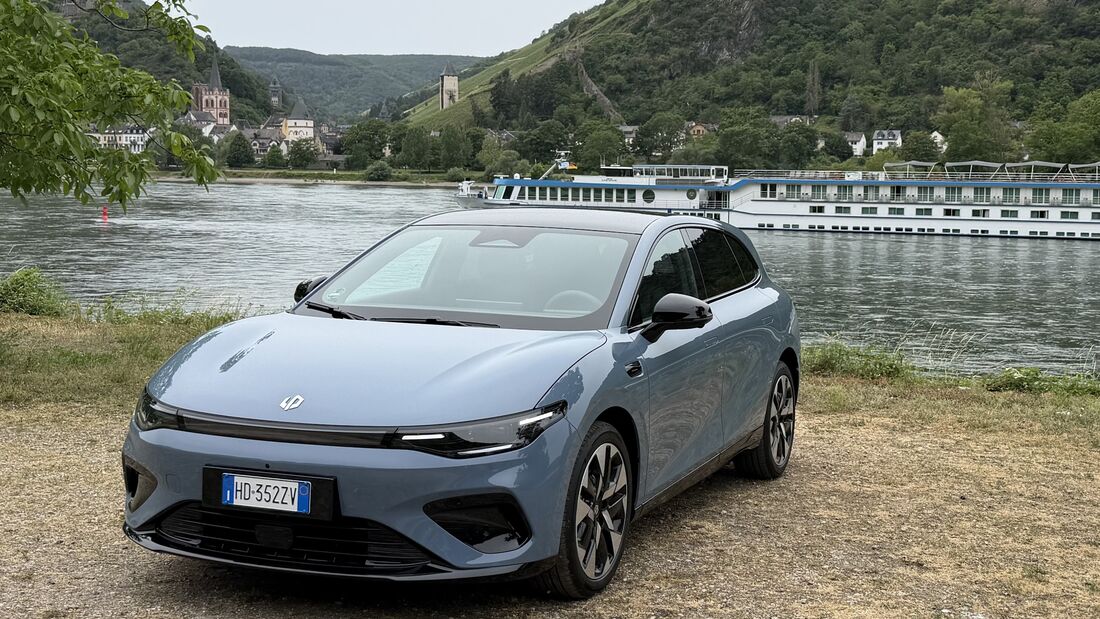 Leapmotor B05 in hellblauer Lackierung an einem Flussufer mit Berglandschaft im Hintergrund.