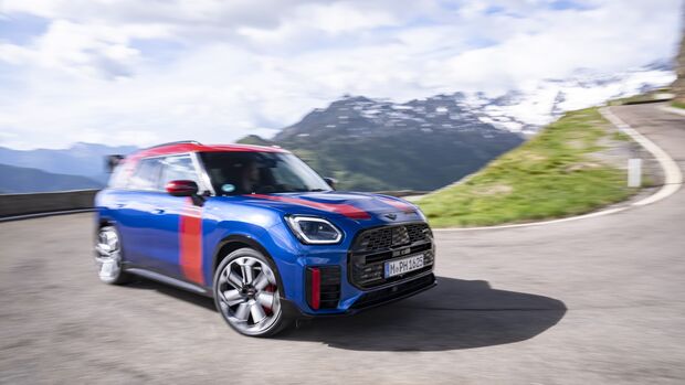 MINI Countryman JCW während der Fahrt auf einer Bergstraße mit Bewegungsunschärfe.