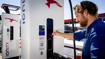 Mann startet einen Ladevorgang an einer IONITY-Schnellladestation mit Ladekarte.