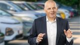 Martin Kössler steht vor geparkten Fahrzeugen und spricht gestikulierend über Fuhrpark- und Mobilitätslösungen
