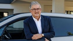 Martin Rada, CEO von vibe moves you, steht neben einem Fahrzeug und blickt in die Kamera.