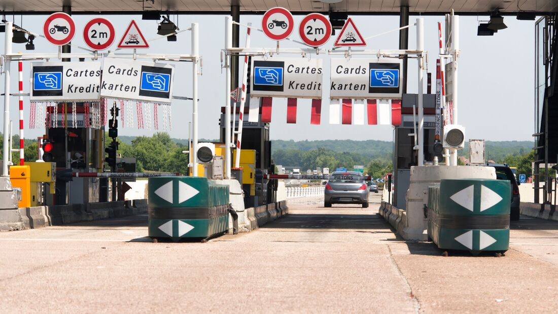 Mautstation auf einer Autobahn in Europa mit Fahrspuren für Kreditkartenzahlung und Verkehrsschildern