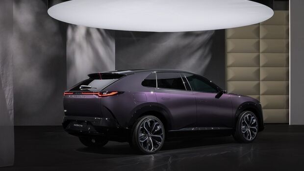 Mazda CX-6e in schraeger Heckansicht mit LED-Lichtband, Spoiler und dunkler Verglasung im Studio.