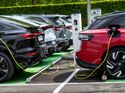 Mehrere Elektroautos der Volkswagen Gruppe laden an öffentlichen Ladepunkten.