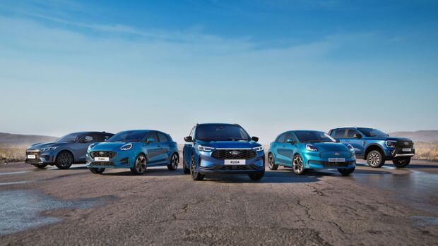 Mehrere Ford-Modelle nebeneinander in einer Außenaufnahme auf offenem Terrain.