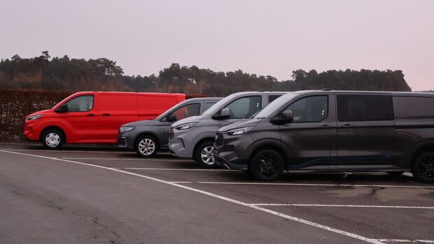Mehrere Ford Transit und Transit Custom stehen nebeneinander auf einem Parkplatz beim Ford Pro Leisure Experience Event in Lommel.