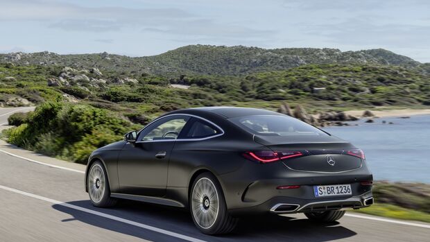Mercedes CLE Coupé fährt in Dreiviertelheckansicht auf einer Straße entlang der Küste.