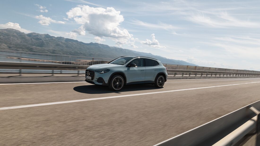 Mercedes GLA fährt auf einer Brücke entlang einer Küstenlandschaft, aufgenommen aus der Seitenperspektive.