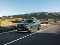 Mercedes GLS SUV in Frontansicht auf kurviger Straße in bergiger Landschaft