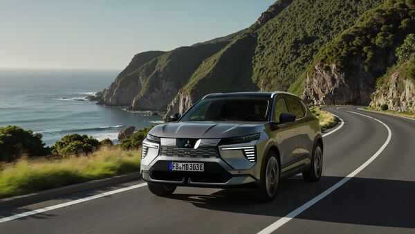 Mitsubishi Eclipse Cross Elektro-SUV fährt auf Küstenstraße mit Meerblick