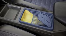 Mittelkonsole des Renault 5 E-Tech Electric mit blau-gelbem Ablagefach zwischen den Vordersitzen.