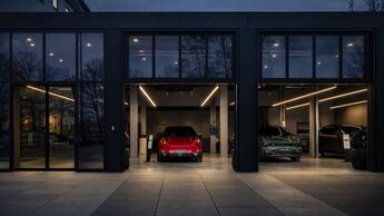 Moderne Lynk & Co Fahrzeugausstellung mit Elektroautos in beleuchtetem Autohaus bei Abenddämmerung.