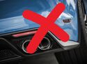 Nahaufnahme eines Auto-Auspuffs mit rotem Kreuz als Symbol gegen Verbrenner im Dienstwagenkontext