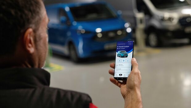 Nutzer bedient eine Smartphone-App zur Steuerung und Ueberwachung eines elektrischen Ford Nutzfahrzeugs in der Flotte.