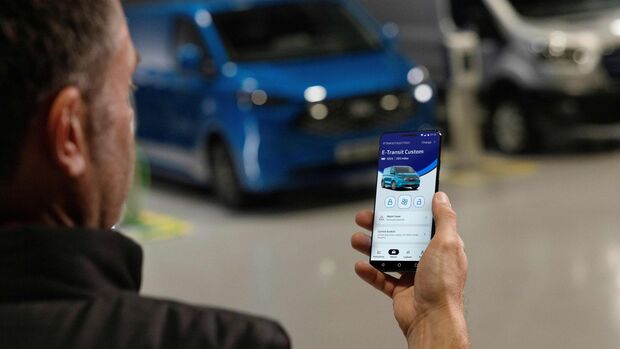 Nutzer steuert Funktionen eines Ford E-Transit Custom über eine Ford-Pro-App auf dem Smartphone.