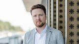 Oliver Adrian, COO und CRO von chargecloud, im Porträt vor moderner Gebäudearchitektur.