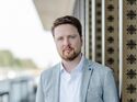 Oliver Adrian, COO und CRO von chargecloud, im Porträt vor moderner Gebäudearchitektur.