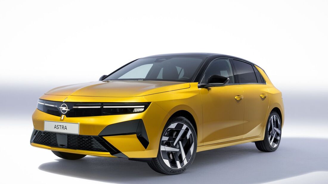 Opel Astra in Gelb, schraeg von vorn im Studio mit schwarzem Dach