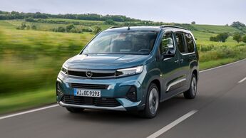 Opel Combo in blauer Lackierung während der Fahrt auf einer Landstraße vor ländlicher Landschaft.