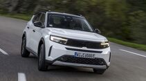 Opel Frontera Electric Extended Range in weiss, frontansicht schraeg, fahrend in einer kurve auf asphaltstrasse
