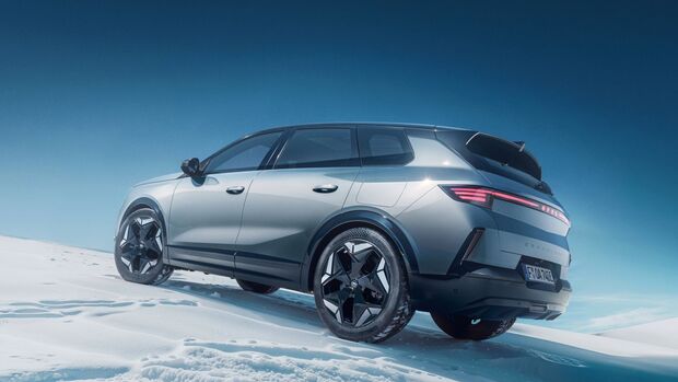 Opel Grandland Electric Ultimate AWD steht auf verschneiter Landschaft in Heck-Seitenansicht, graues Elektro-SUV mit LED-Rueckleuchten und Allradantrieb.